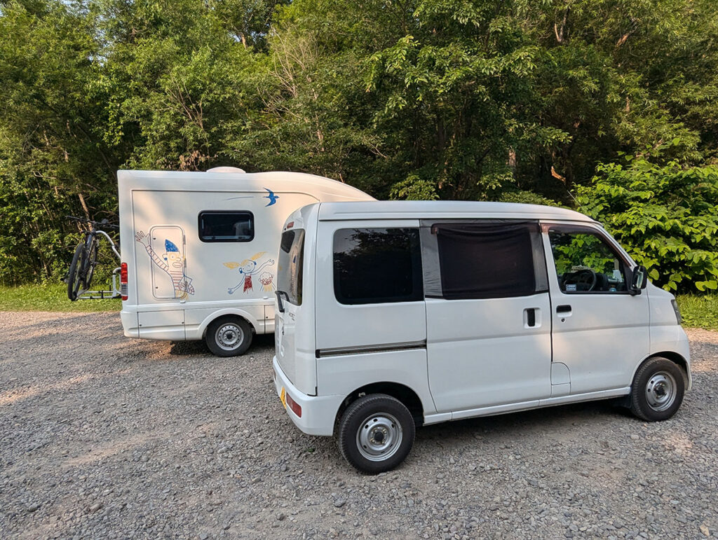 さくらの滝の駐車場に駐車しているキャンピングカーとダイハツ ハイゼットカーゴ