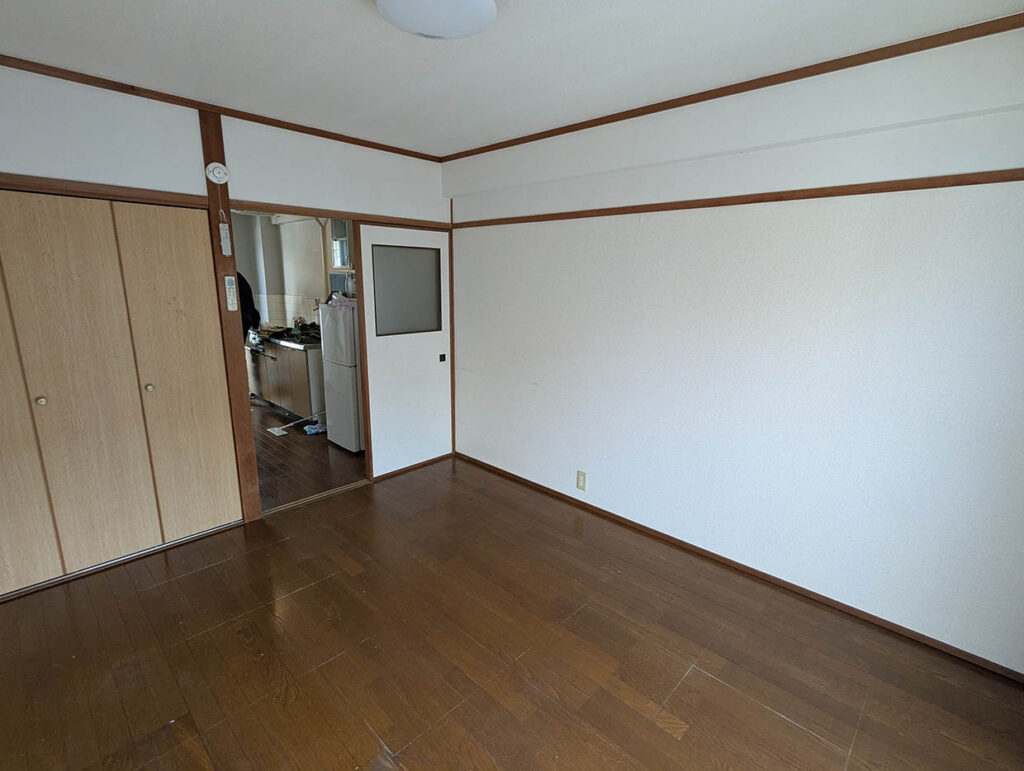 家具がすべて運び出された、引っ越し直後のアパートの部屋とキッチン