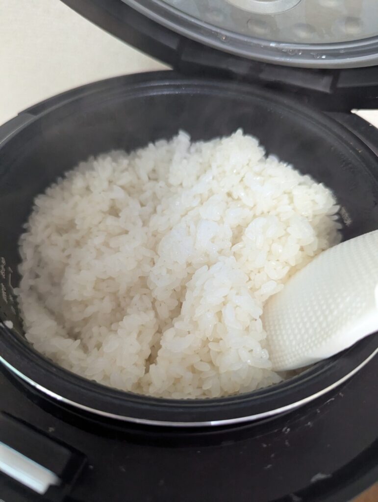炊飯器でふっくら炊き上がったもち米。湯気が立ちのぼり、艶やかな白が美しい。