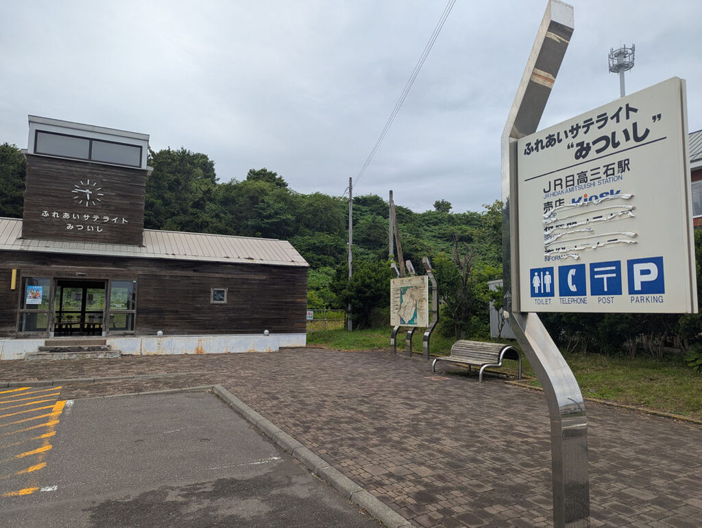 木造の小さな建物「ふれあいサテライトみついし」の外観と駅名看板(旧JR日高三石駅跡)
