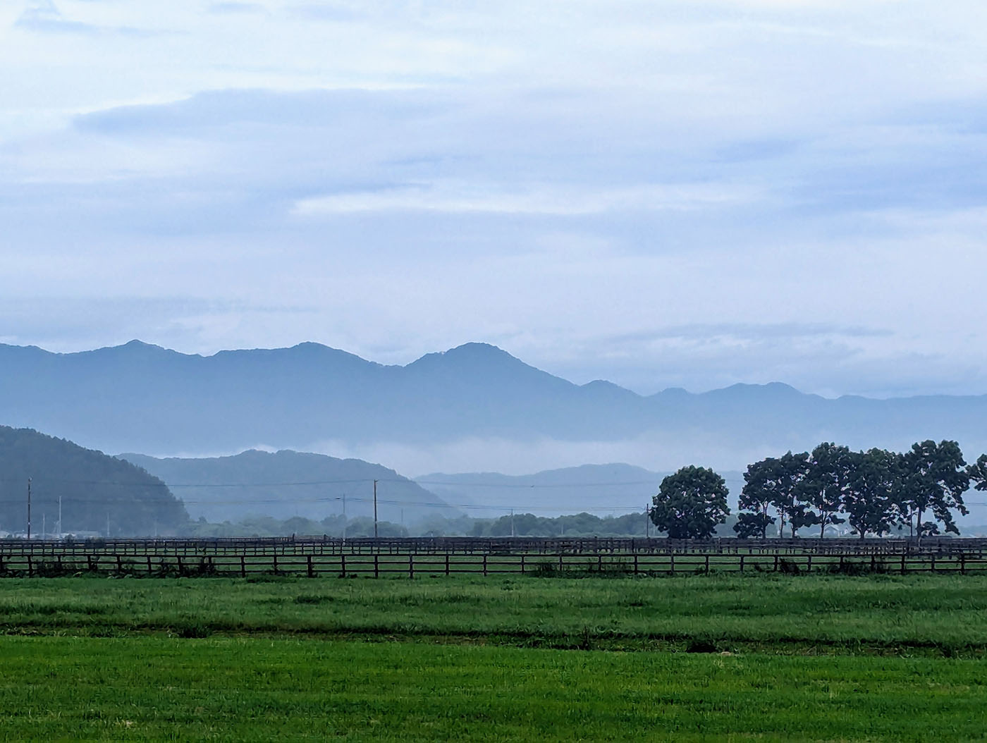 北海道・道の駅みついし前の牧場と朝もやに包まれた日高山脈の風景