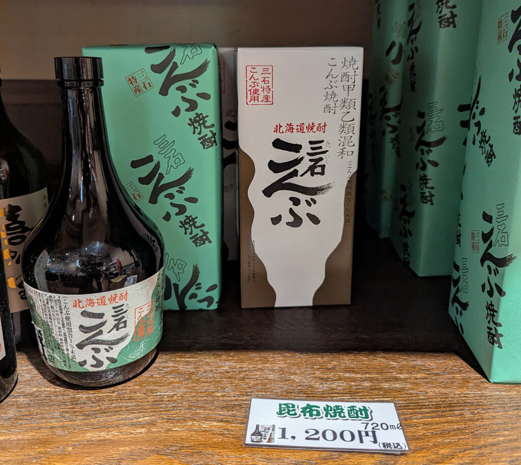 三石特産の北海道産こんぶ焼酎「三石こんぶ」、720ml瓶が売店に陳列されている様子。価格は税込1,200円。