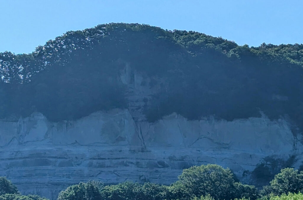 上愛冠の白い断崖とその前に広がる緑の草地、青空に映える風景