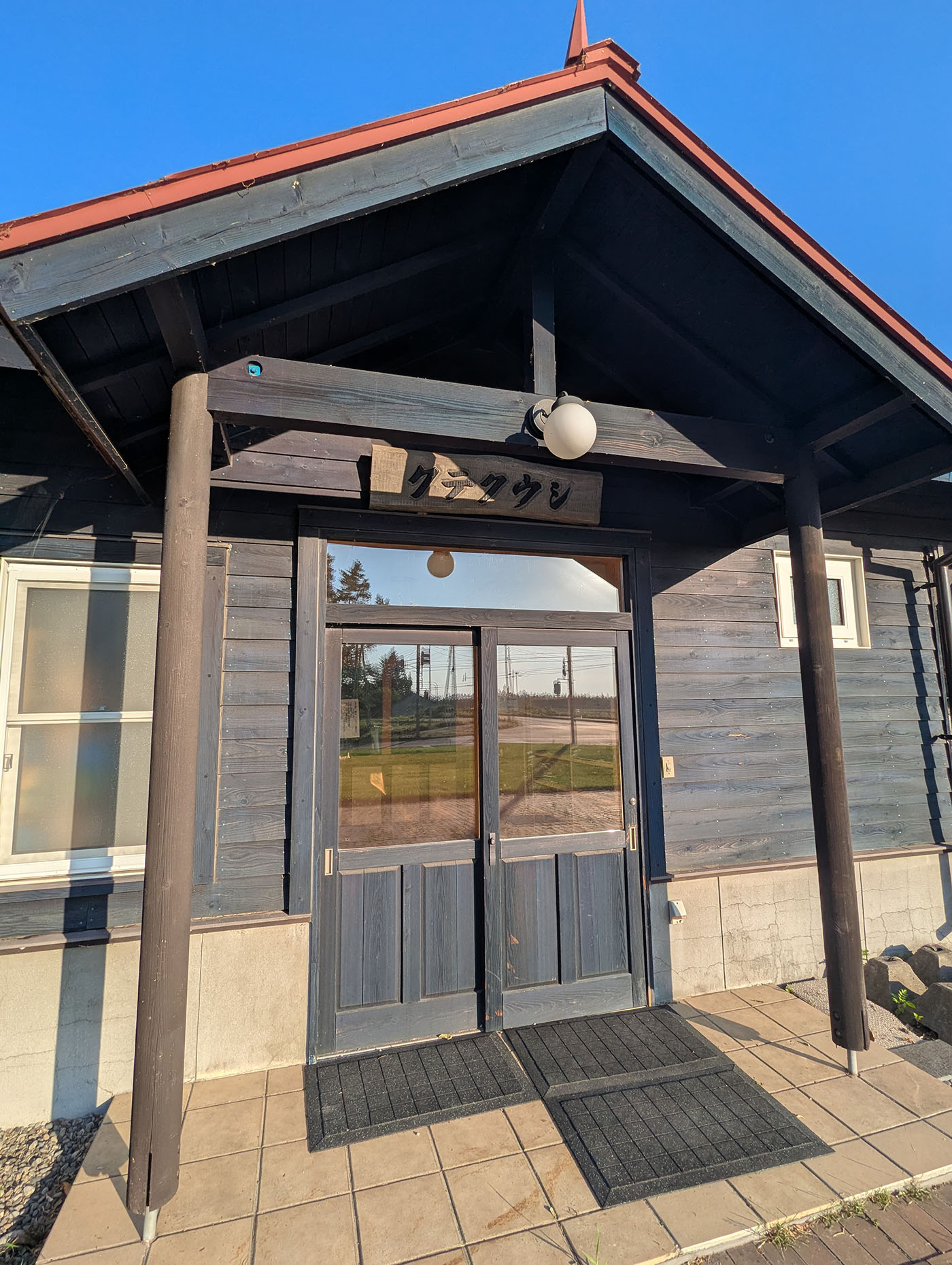 「クテクウシ」と書かれた木の看板が掲げられた、駅逓再現建物の正面玄関。