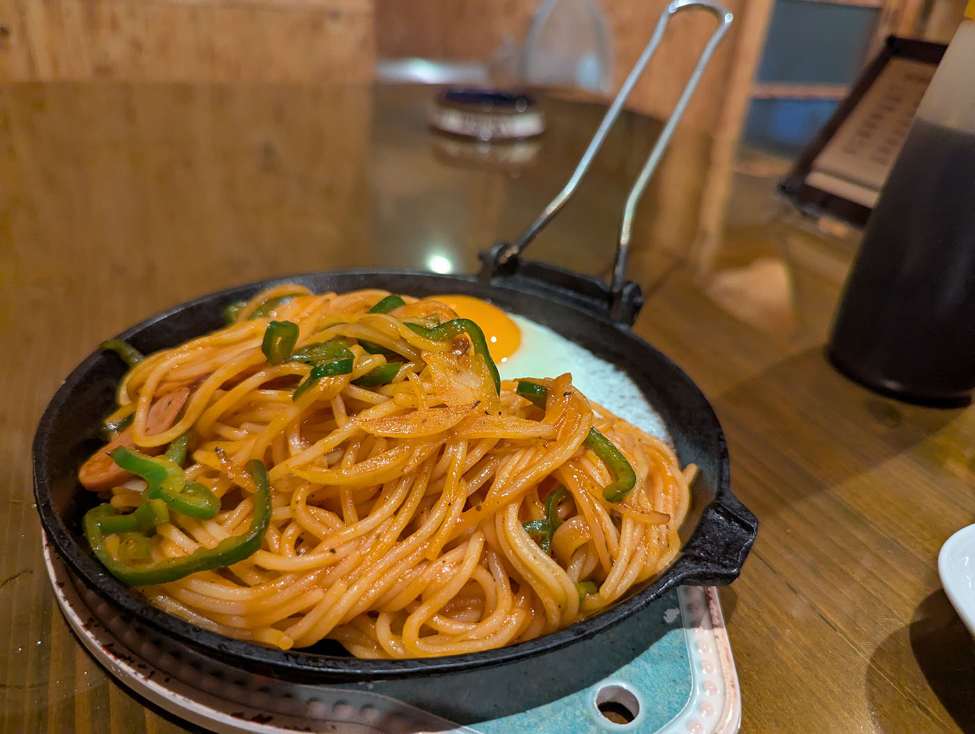 五三五の名物ナポリタン。鉄板の上に盛られ、目玉焼きが添えられている。