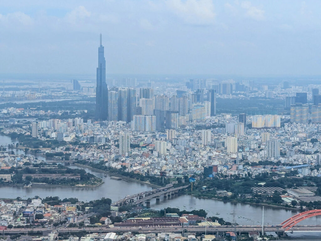 ベトナム・ホーチミン市を飛行機から見下ろした風景。高層ビル群とランドマーク81、サイゴン川が広がっている。