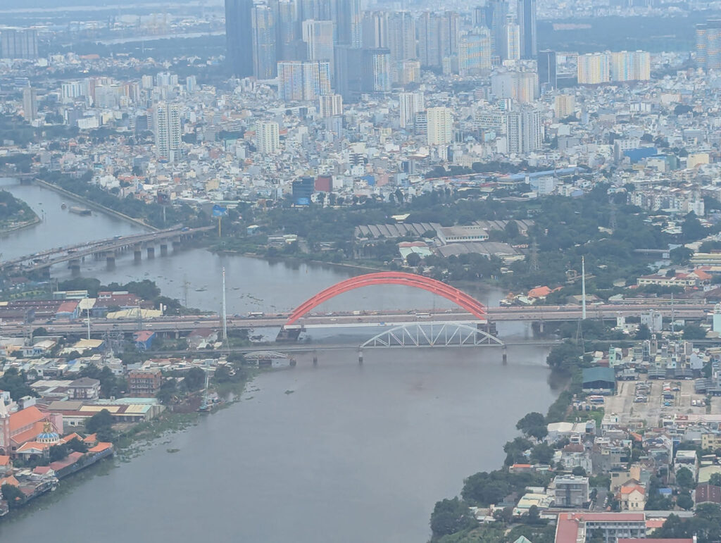 ベトナム・ホーチミン市を飛行機から見下ろした風景。高層ビル群とランドマーク81、サイゴン川が広がっている。