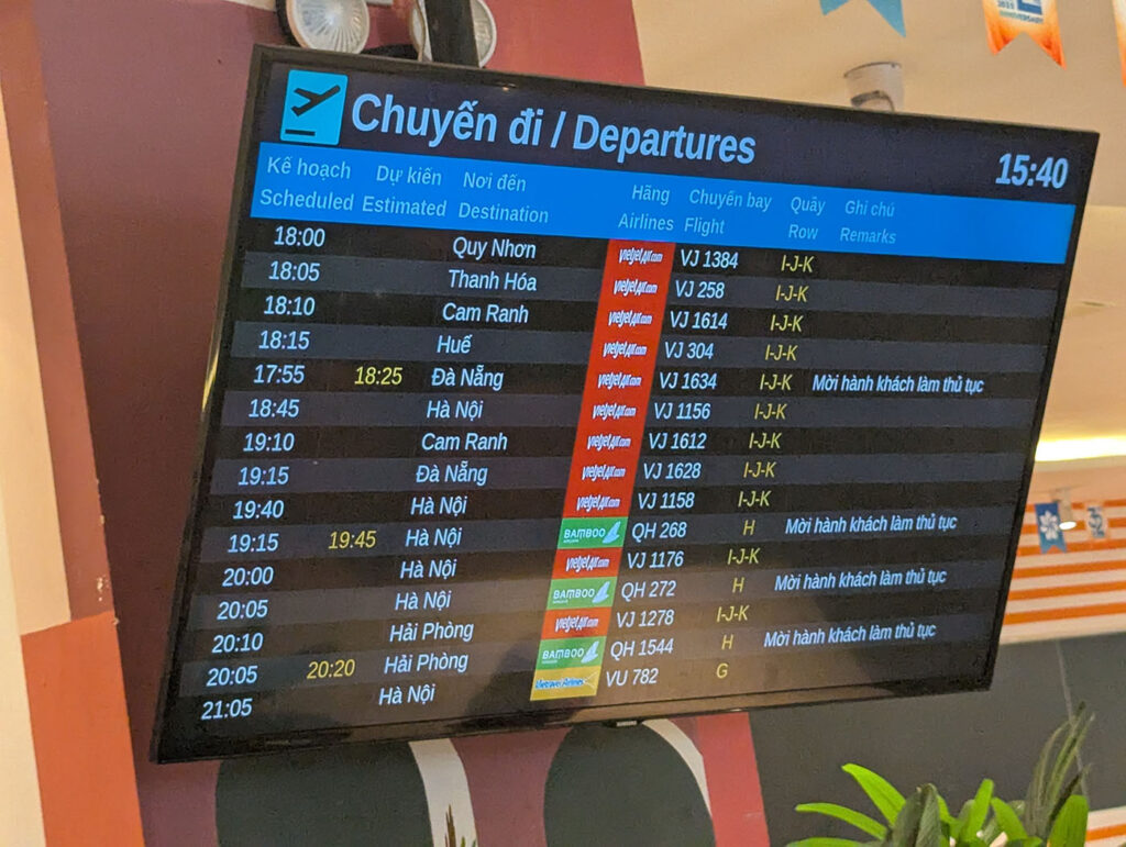 ベトナムの空港出発案内ボード。フライト時刻や行き先、遅延情報が表示されている。