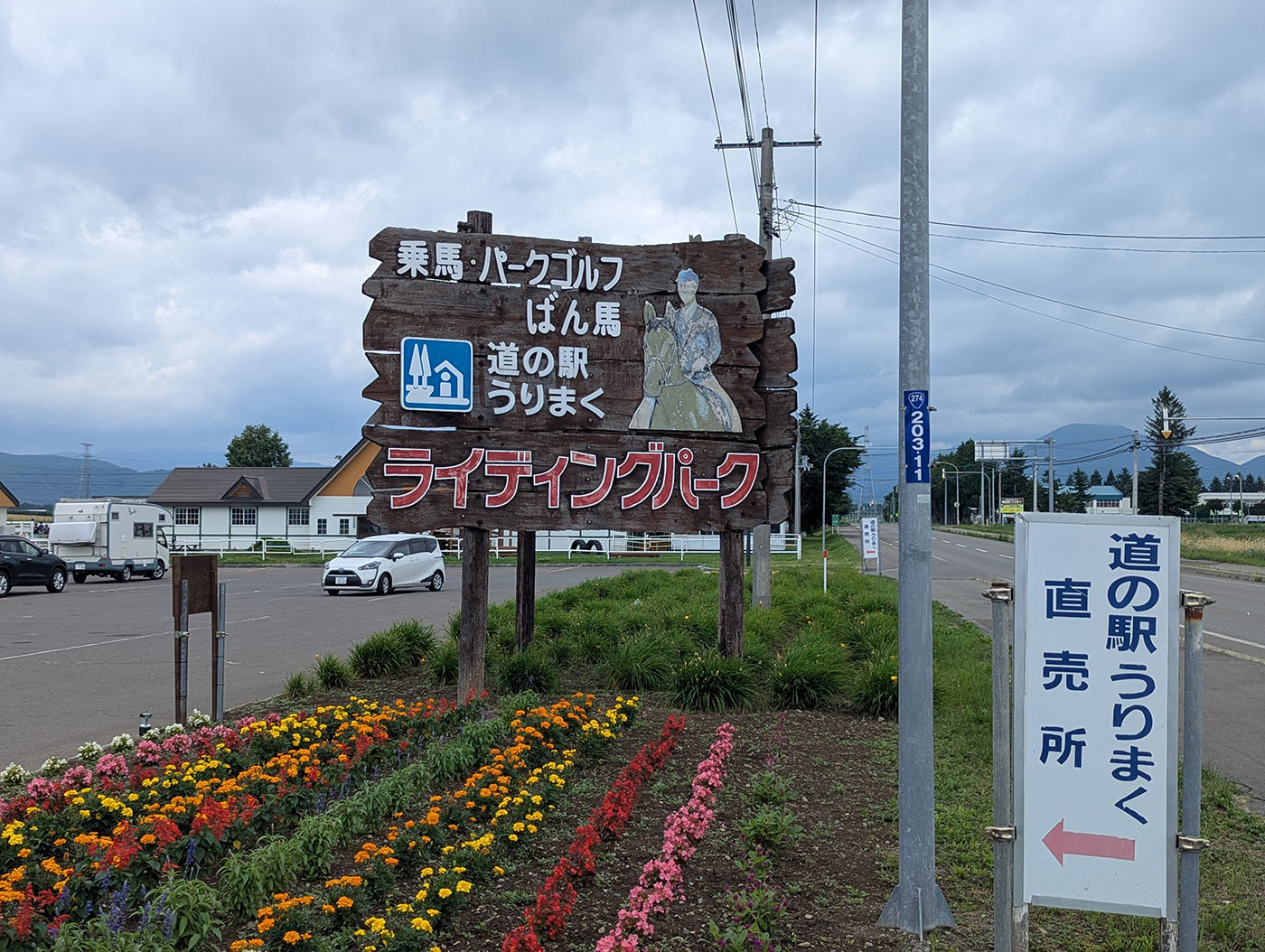 道の駅うりまくの木製看板と色とりどりの花壇