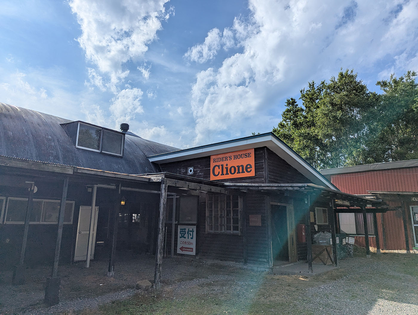 北海道・斜里町にある「RIDER'S HOUSE Clione」の外観。レトロな木造建物とオレンジ色の看板が目印。