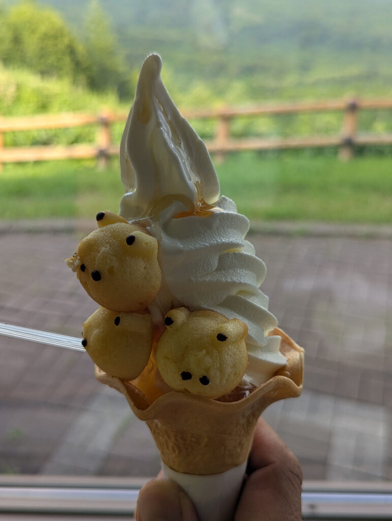 開陽台名物「しあわせのはちみつソフト」。地元産生乳のソフトクリームに、はちみつとクマ型の焼き菓子を添えたかわいらしい一品。