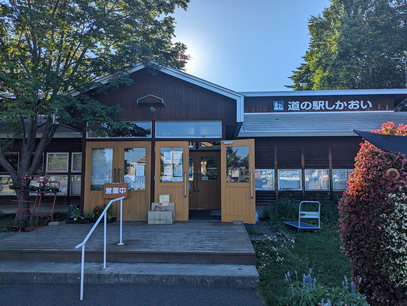 木造の温もりを感じる「道の駅しかおい」の正面入口。夏の日差しを受けながら、営業中の看板が掛かっている。
