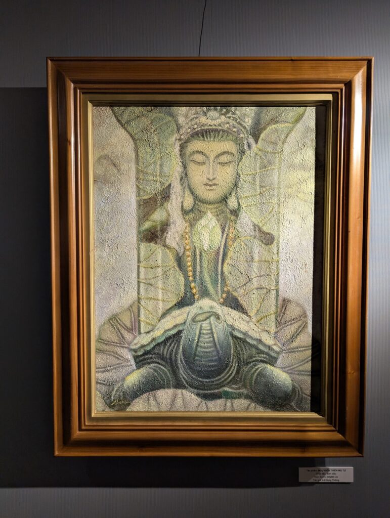 木製額に収められた、穏やかな表情の観音菩薩と亀をモチーフにした絵画。淡い緑と金色を基調に、柔らかな質感で描かれている。
