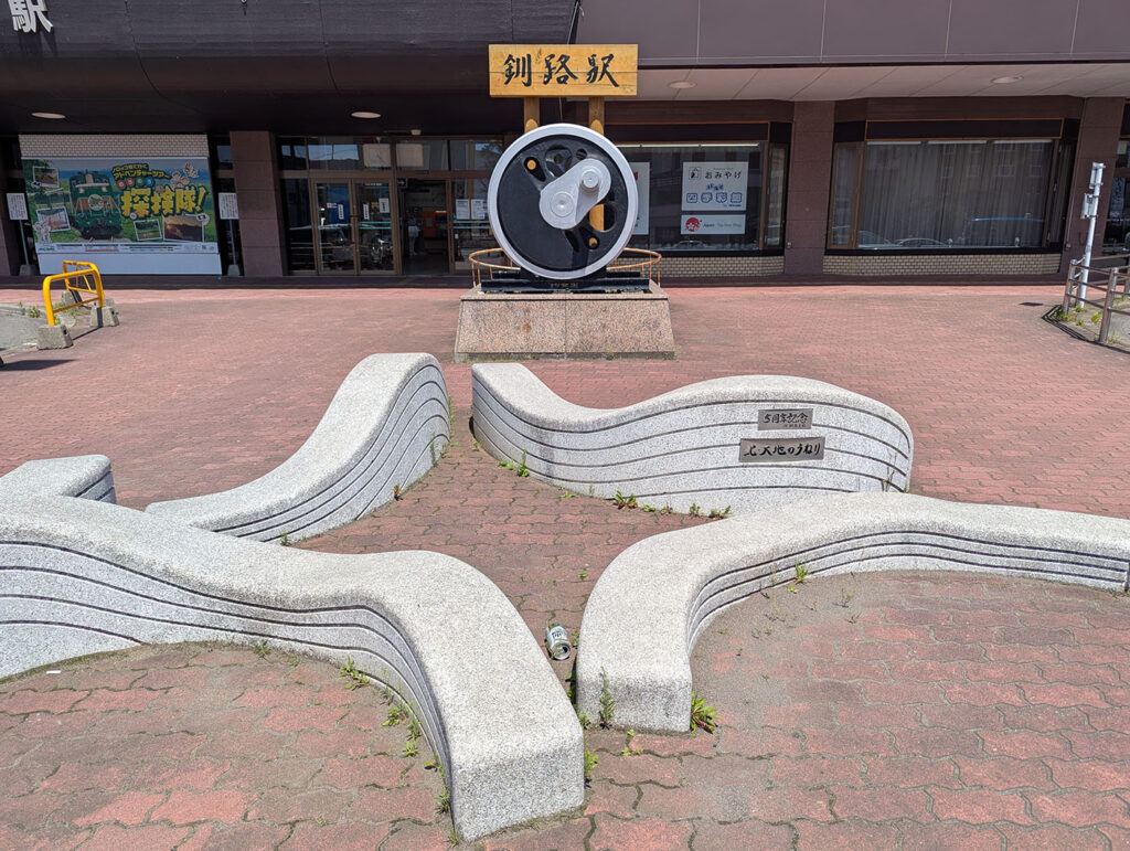 釧路駅前に設置された「北・大地のうねり」彫刻。5周年記念として設置されたモニュメントと駅前広場の様子。