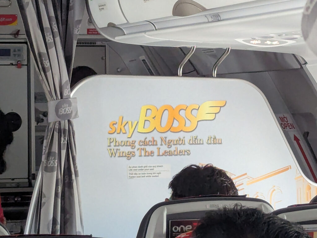 ベトジェットの機内前方に掲げられたSkyBOSSのロゴとキャッチコピー「Wings The Leaders」。カーテンや座席越しに、上位クラスの雰囲気が漂う。