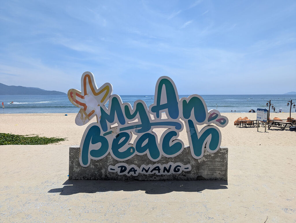 砂浜に設置された「My An Beach - Da Nang」の大きな看板と、その向こうに広がる海